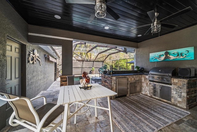 view of patio featuring an outdoor kitchen, grilling area, a lanai, and ceiling fan