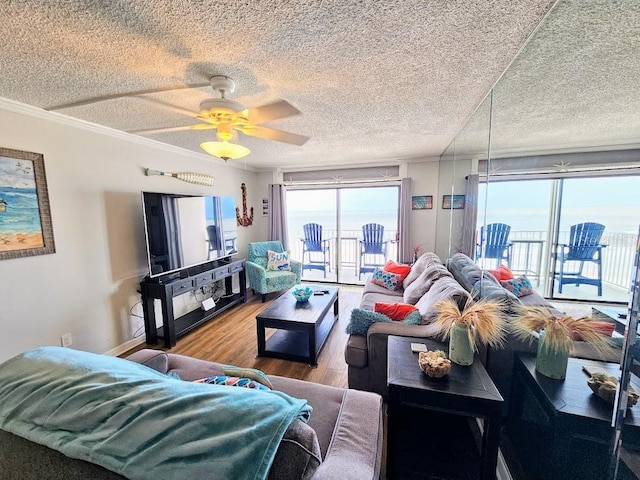 living room with ceiling fan, crown molding, a textured ceiling, and hardwood / wood-style flooring