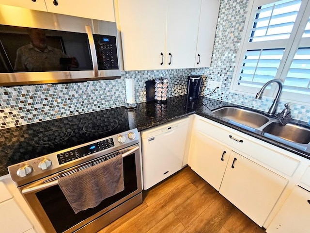 kitchen featuring sink, white cabinetry, backsplash, and appliances with stainless steel finishes