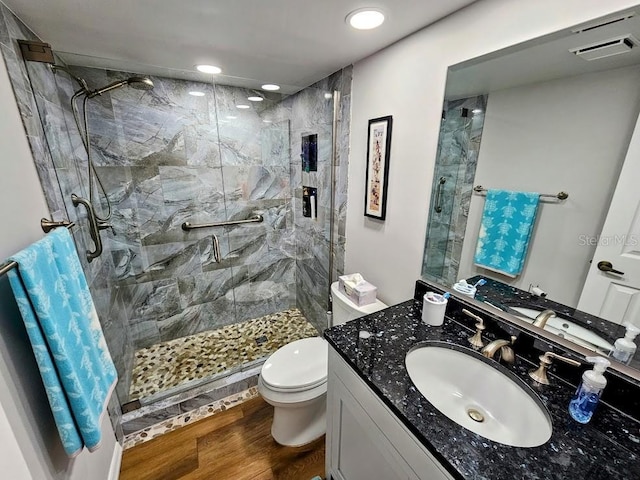 bathroom with hardwood / wood-style flooring, vanity, toilet, and an enclosed shower