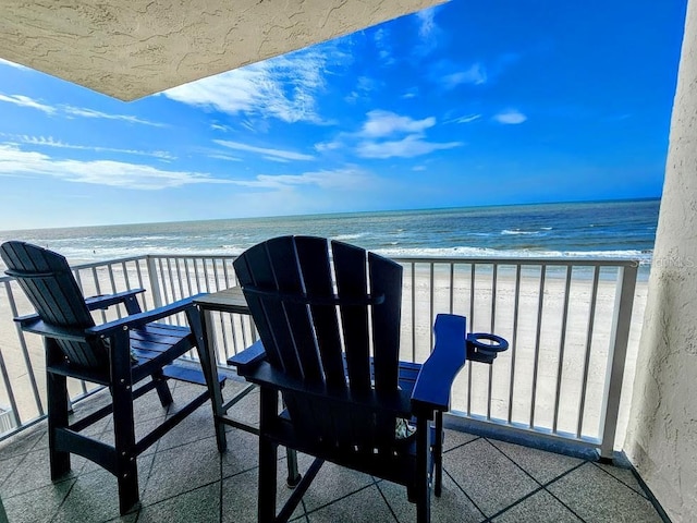 balcony featuring a water view and a view of the beach