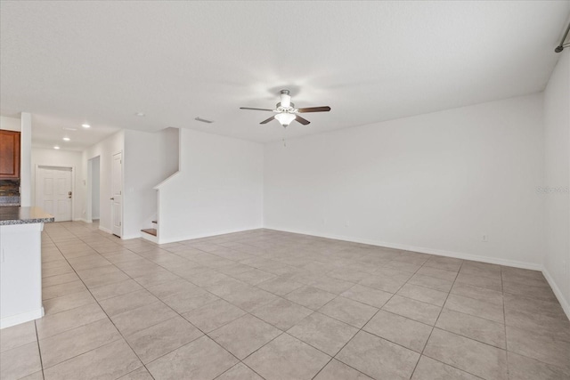 tiled spare room featuring ceiling fan