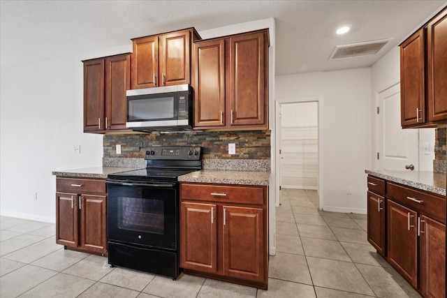 kitchen with decorative backsplash, black electric range oven, light stone countertops, and light tile patterned floors