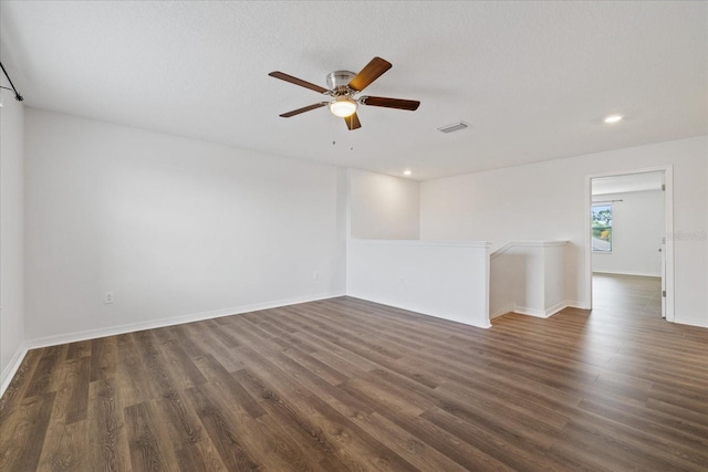 spare room featuring a textured ceiling, ceiling fan, and dark wood-type flooring