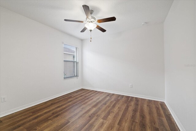 spare room with dark hardwood / wood-style floors and ceiling fan