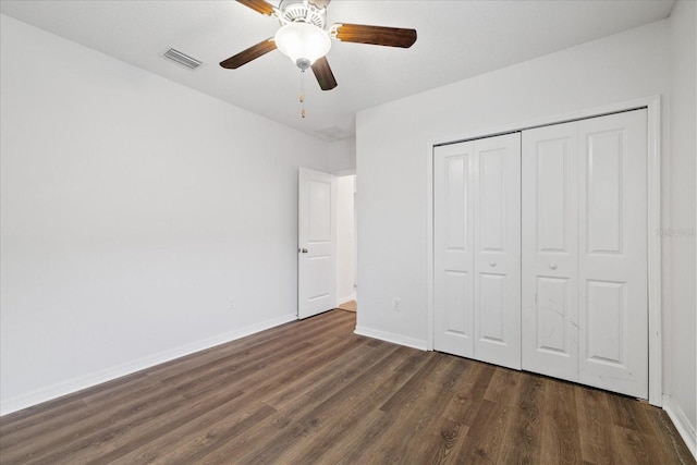 unfurnished bedroom featuring ceiling fan, dark hardwood / wood-style flooring, and a closet