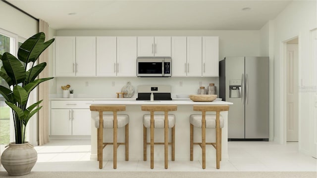 kitchen with white cabinets, a kitchen breakfast bar, stainless steel appliances, and a center island with sink