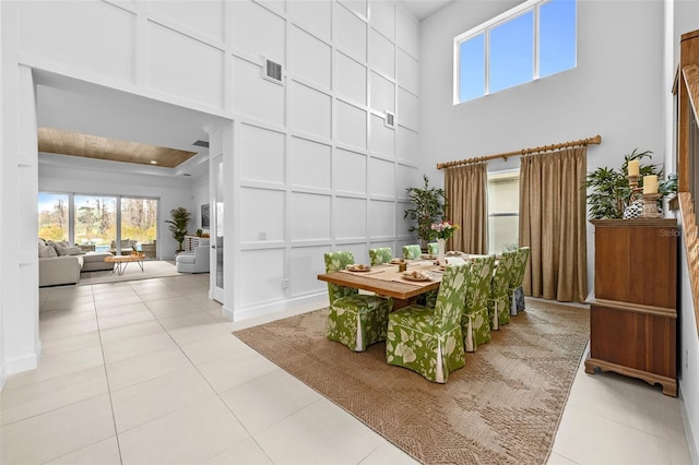 tiled dining room featuring a towering ceiling