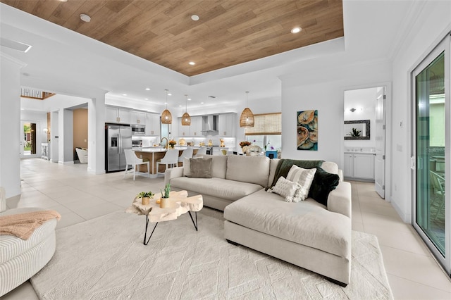 living room with a tray ceiling, wooden ceiling, and light tile patterned flooring