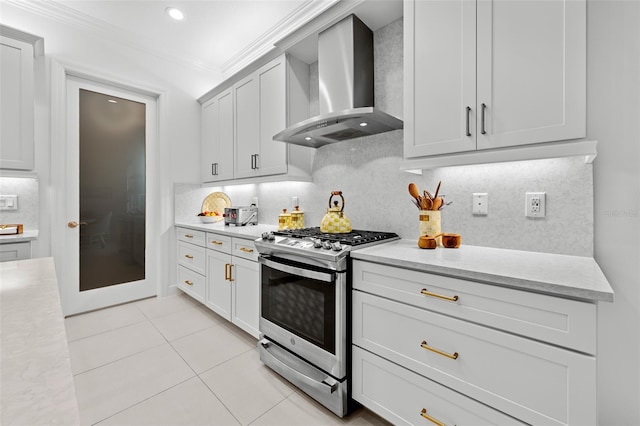 kitchen featuring gas stove, crown molding, light tile patterned floors, decorative backsplash, and wall chimney range hood