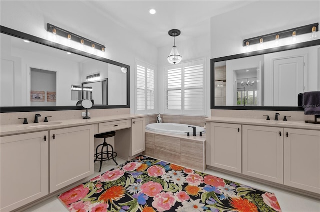 bathroom with tiled tub, vanity, and tile patterned floors