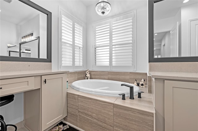 bathroom with tiled tub and vanity