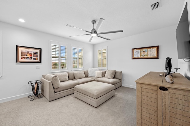 carpeted living room with ceiling fan