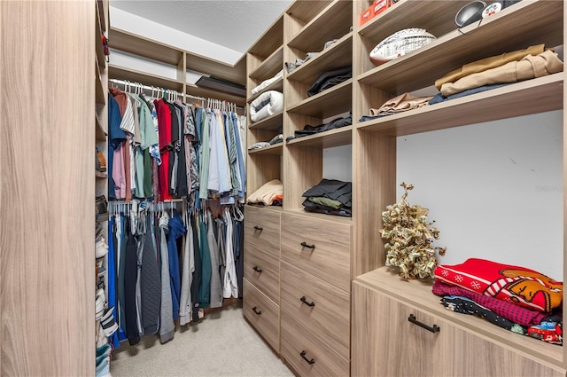 walk in closet featuring light colored carpet