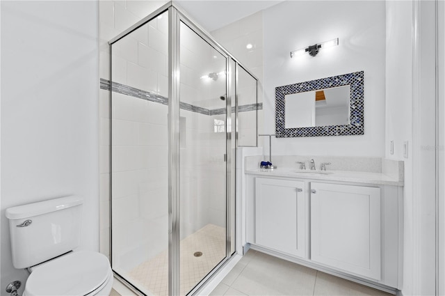 bathroom featuring walk in shower, vanity, toilet, and tile patterned flooring