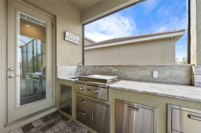 view of patio featuring area for grilling, exterior kitchen, and sink