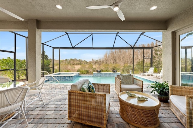 view of patio featuring a pool with hot tub, a lanai, outdoor lounge area, and pool water feature