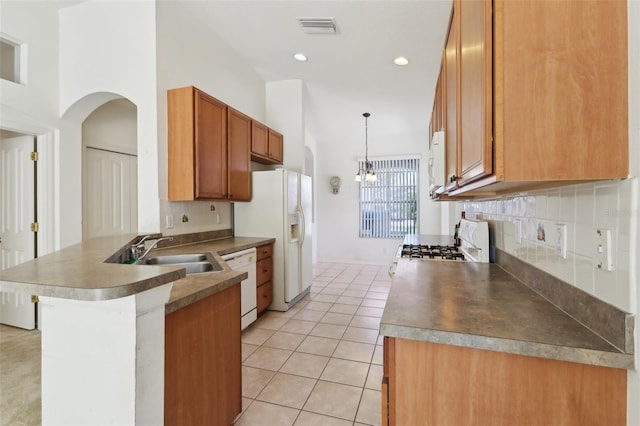 kitchen featuring kitchen peninsula, backsplash, white appliances, decorative light fixtures, and light tile patterned flooring