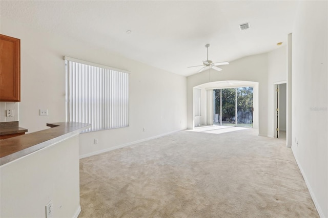 unfurnished living room with light colored carpet, ceiling fan, and lofted ceiling