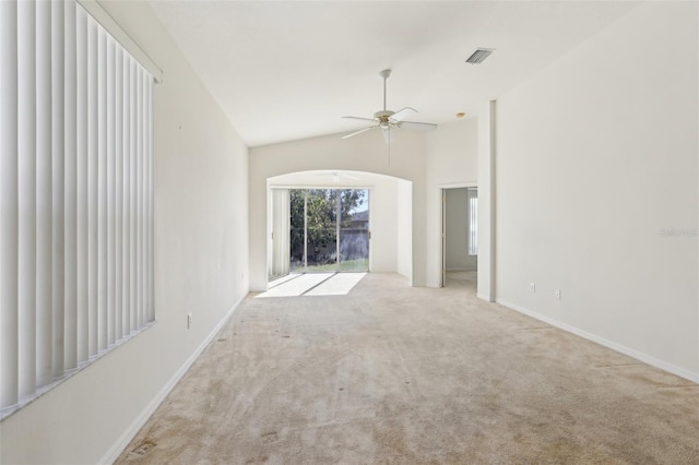 unfurnished living room with ceiling fan, light colored carpet, and lofted ceiling