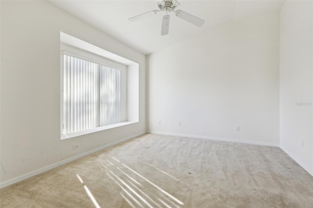 carpeted spare room featuring ceiling fan