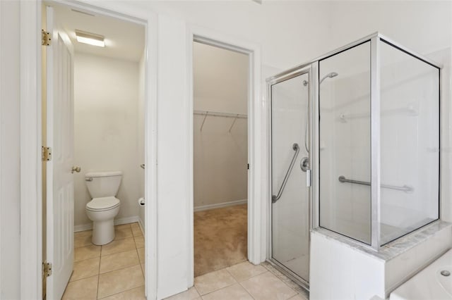 bathroom with tile patterned floors, a shower with door, and toilet