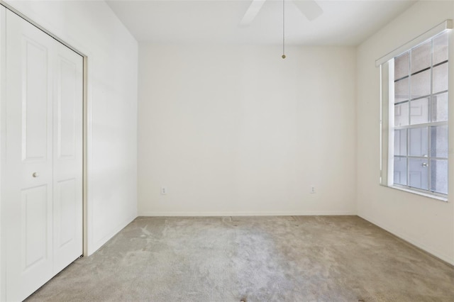 interior space featuring ceiling fan, a closet, and light colored carpet