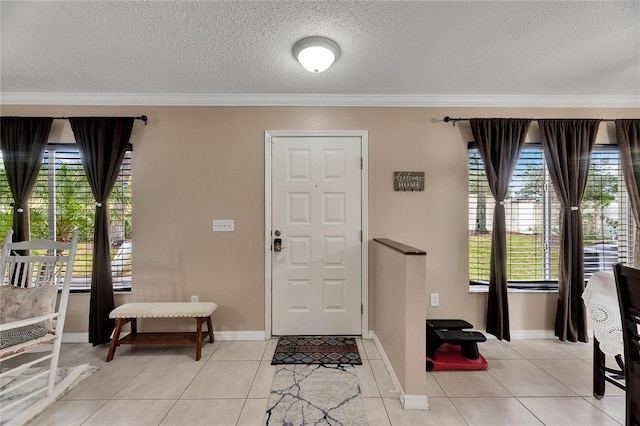 foyer with a textured ceiling, light tile patterned flooring, and crown molding