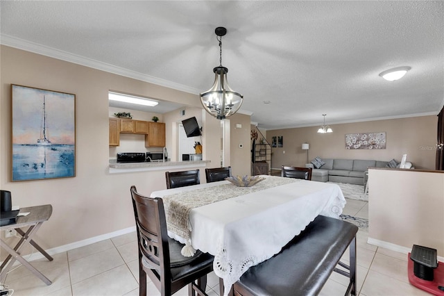 tiled dining area with ornamental molding, a textured ceiling, and an inviting chandelier