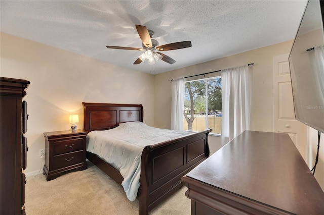 bedroom featuring ceiling fan, light carpet, and a textured ceiling