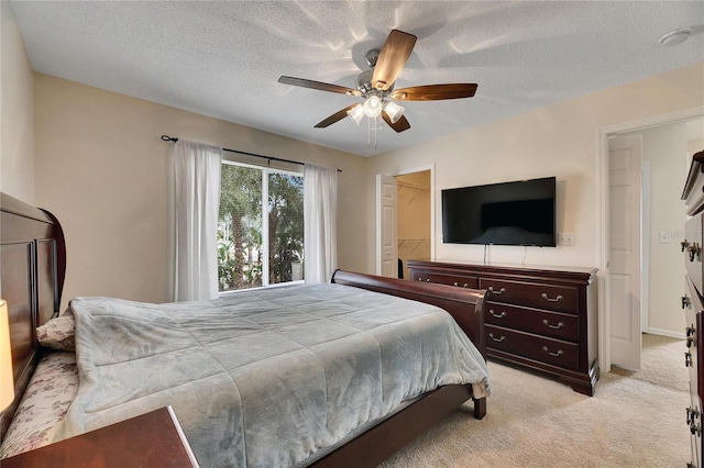 bedroom featuring light carpet, a textured ceiling, and ceiling fan