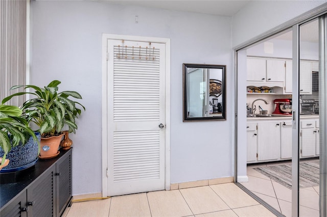 hallway with light tile patterned flooring and sink