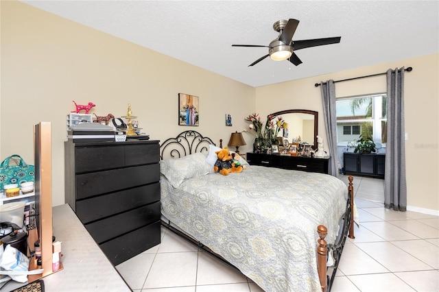 bedroom with a textured ceiling, ceiling fan, and light tile patterned flooring