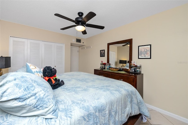 bedroom featuring ceiling fan, a closet, and light tile patterned floors