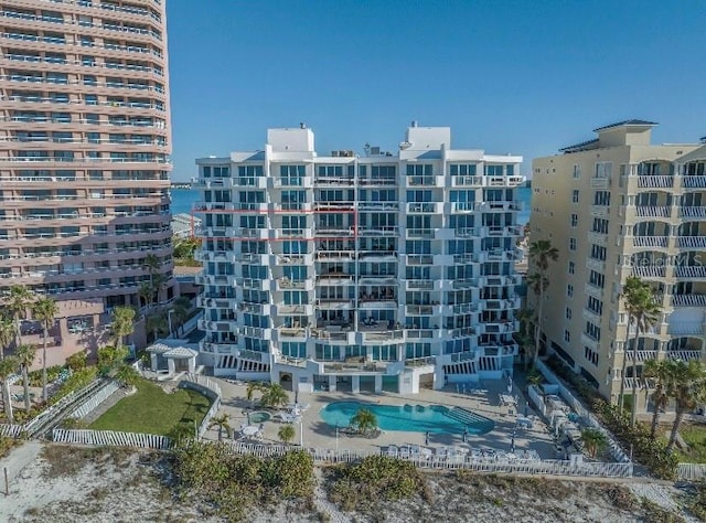 view of building exterior with a water view and a community pool