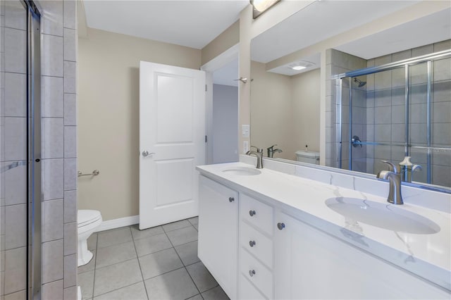 bathroom with tile patterned flooring, vanity, toilet, and an enclosed shower