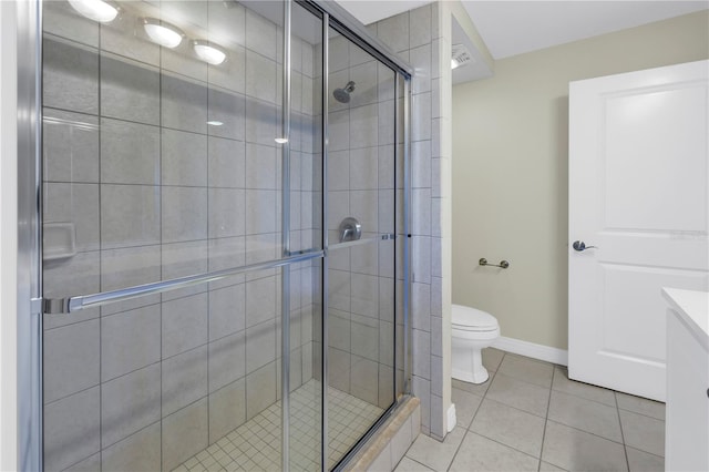 bathroom with tile patterned flooring, vanity, toilet, and a shower with shower door