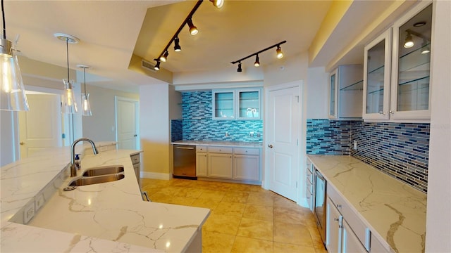 kitchen featuring light stone countertops, visible vents, a sink, decorative backsplash, and decorative light fixtures