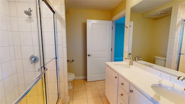 bathroom featuring a stall shower, toilet, and a sink