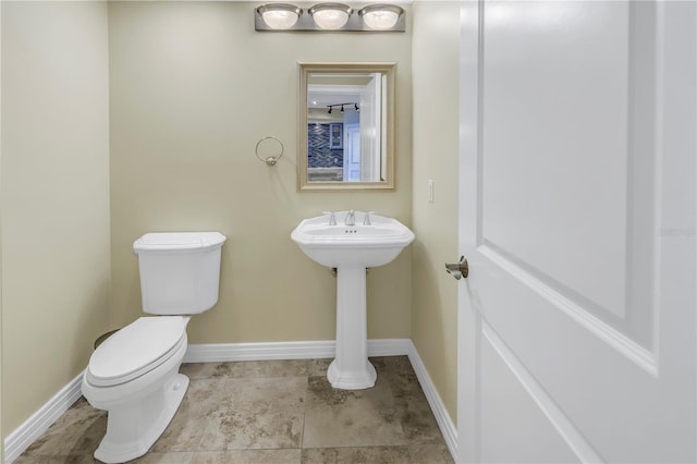 bathroom with toilet and baseboards