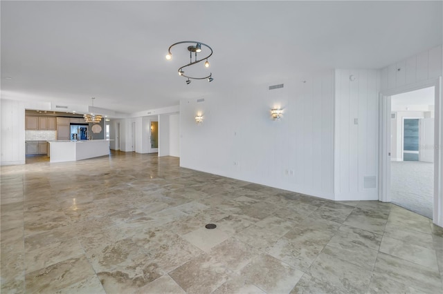 unfurnished living room featuring a chandelier and visible vents