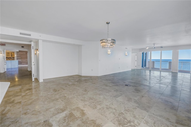 unfurnished room with a chandelier, visible vents, and rail lighting