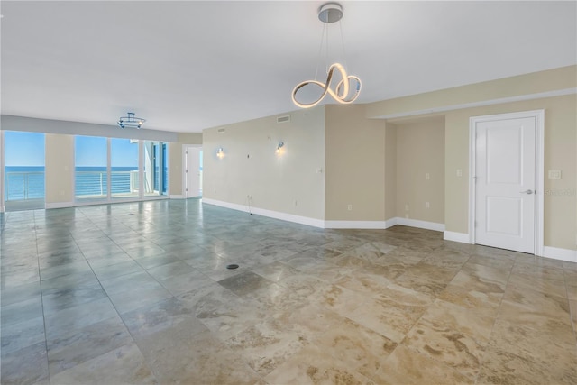 empty room featuring an inviting chandelier, visible vents, and baseboards