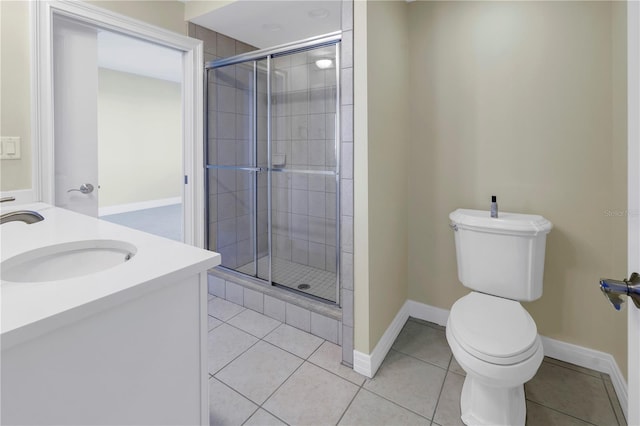 full bath featuring toilet, a shower stall, tile patterned flooring, and baseboards