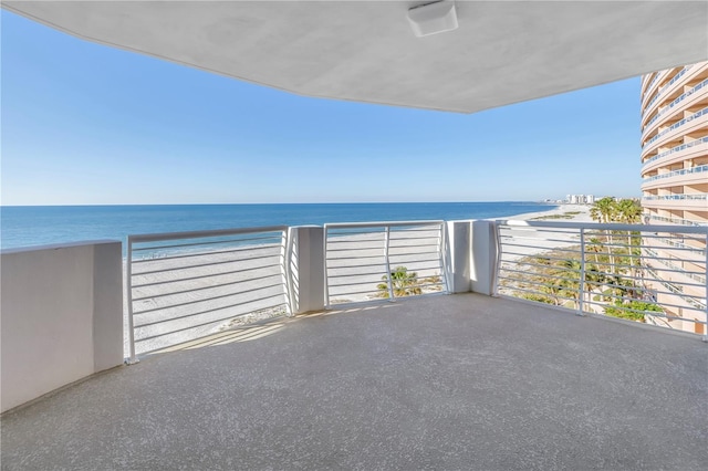 balcony featuring a beach view and a water view