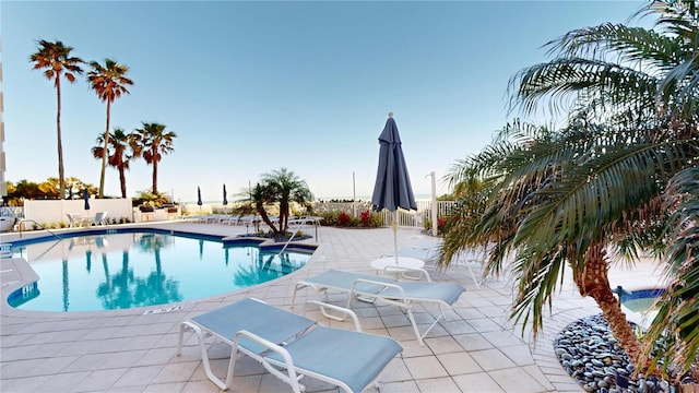 pool featuring fence and a patio area