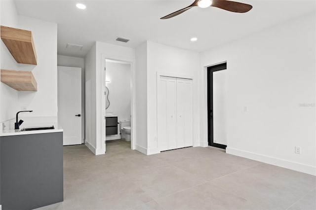 interior space featuring connected bathroom, a closet, ceiling fan, and sink