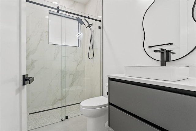 bathroom featuring vanity, toilet, and a shower with shower door