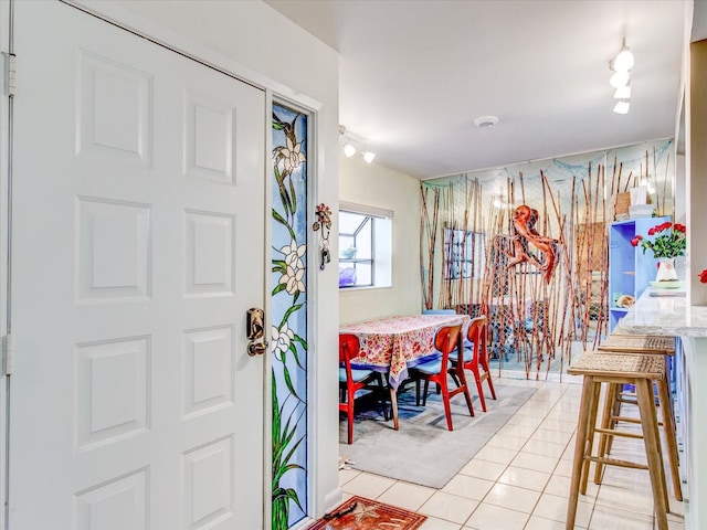 tiled dining room featuring rail lighting