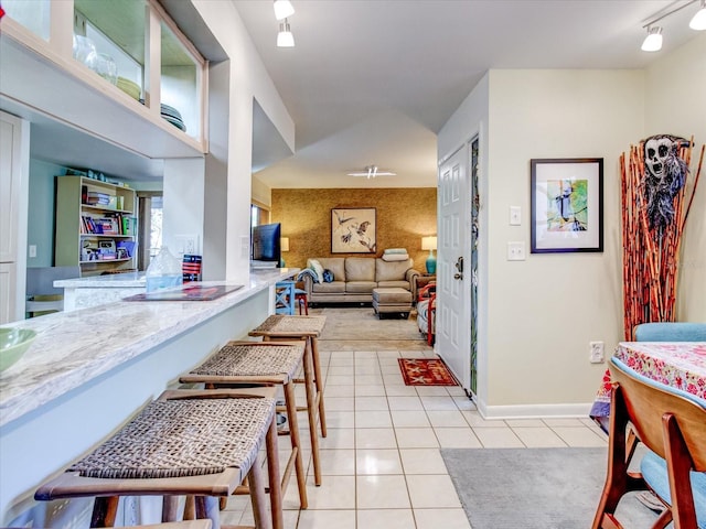 interior space with track lighting and light tile patterned floors